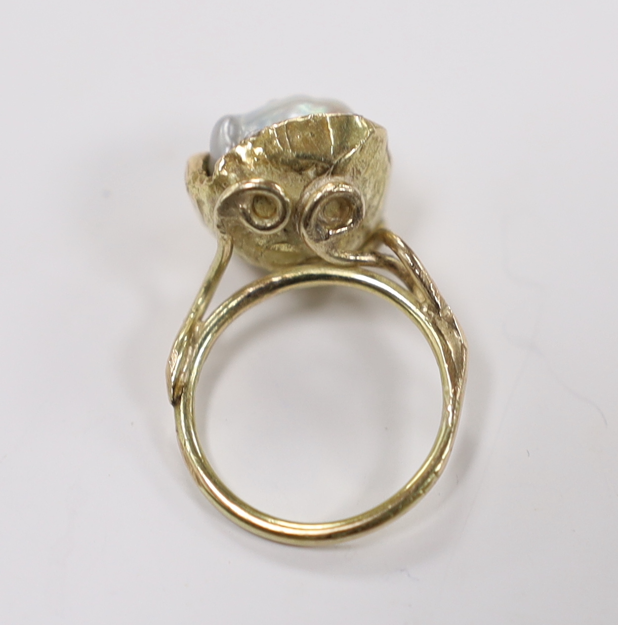 A yellow metal and baroque pearl set ring, with three stone diamond chip set setting, of foliate form, size K, gross weight 6.7 grams.